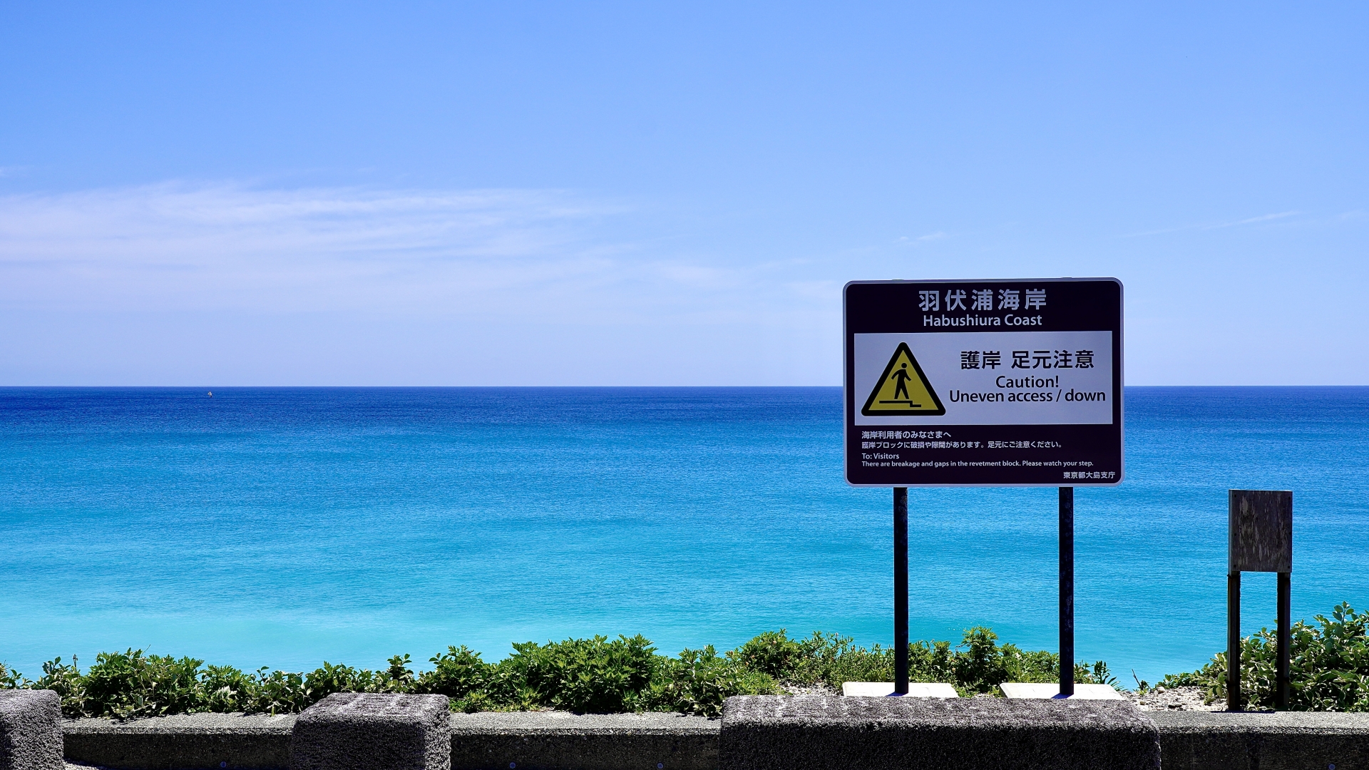 新島の羽伏浦海岸の真っ青な海と警告表示